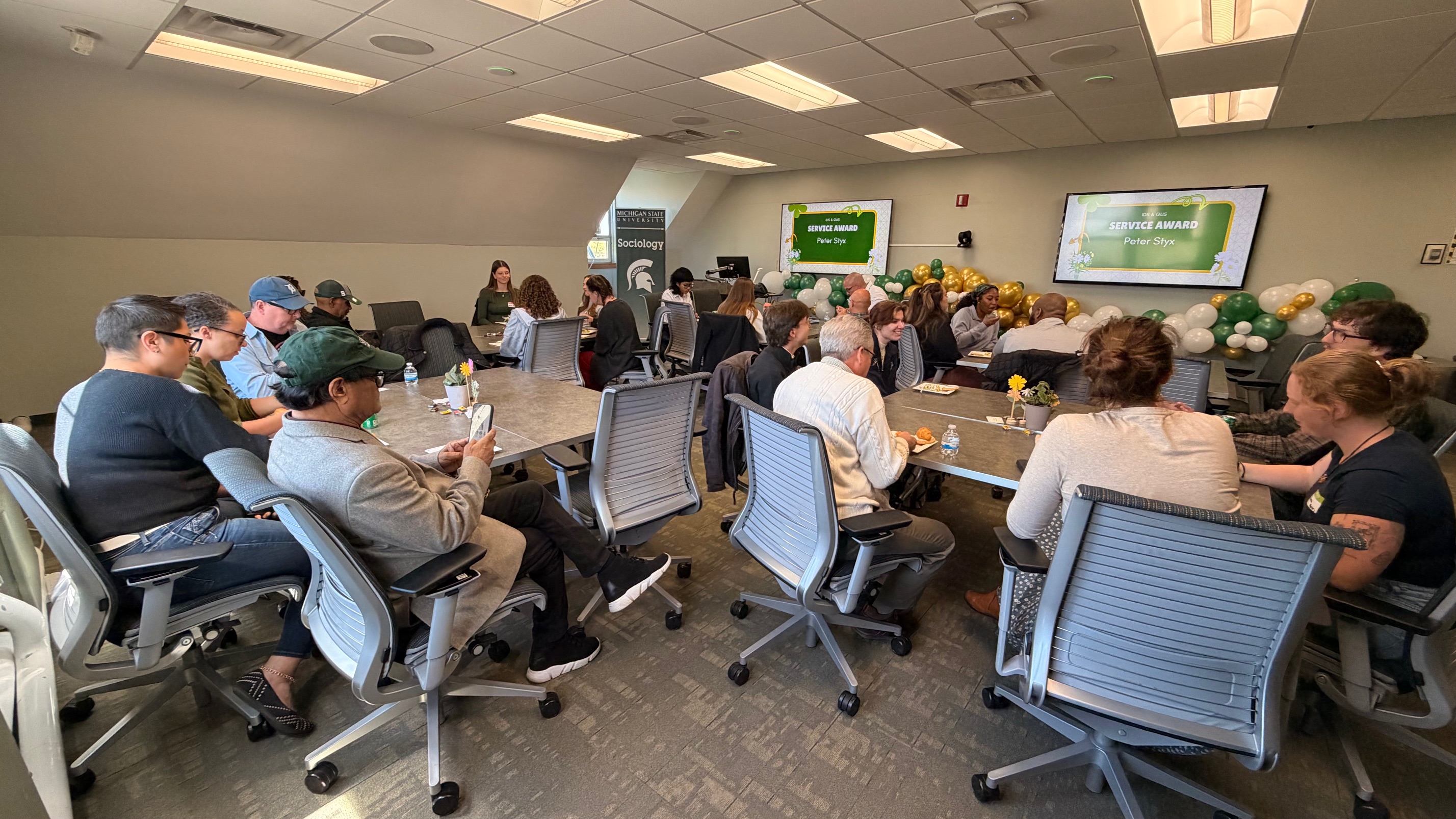 Faculty, staff and students gathering in a room.