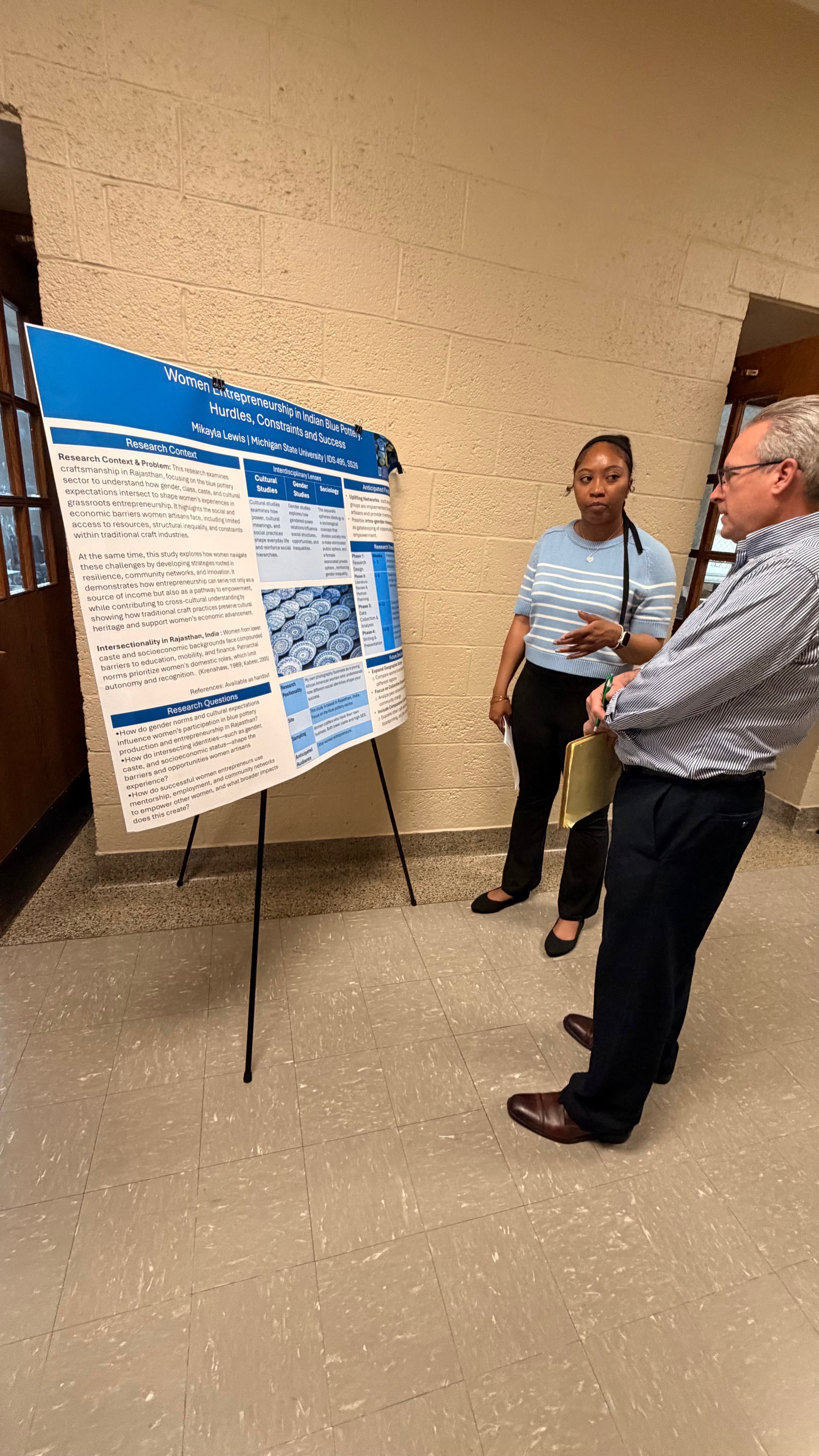 MSU student explaining her research poster to an advisor. 