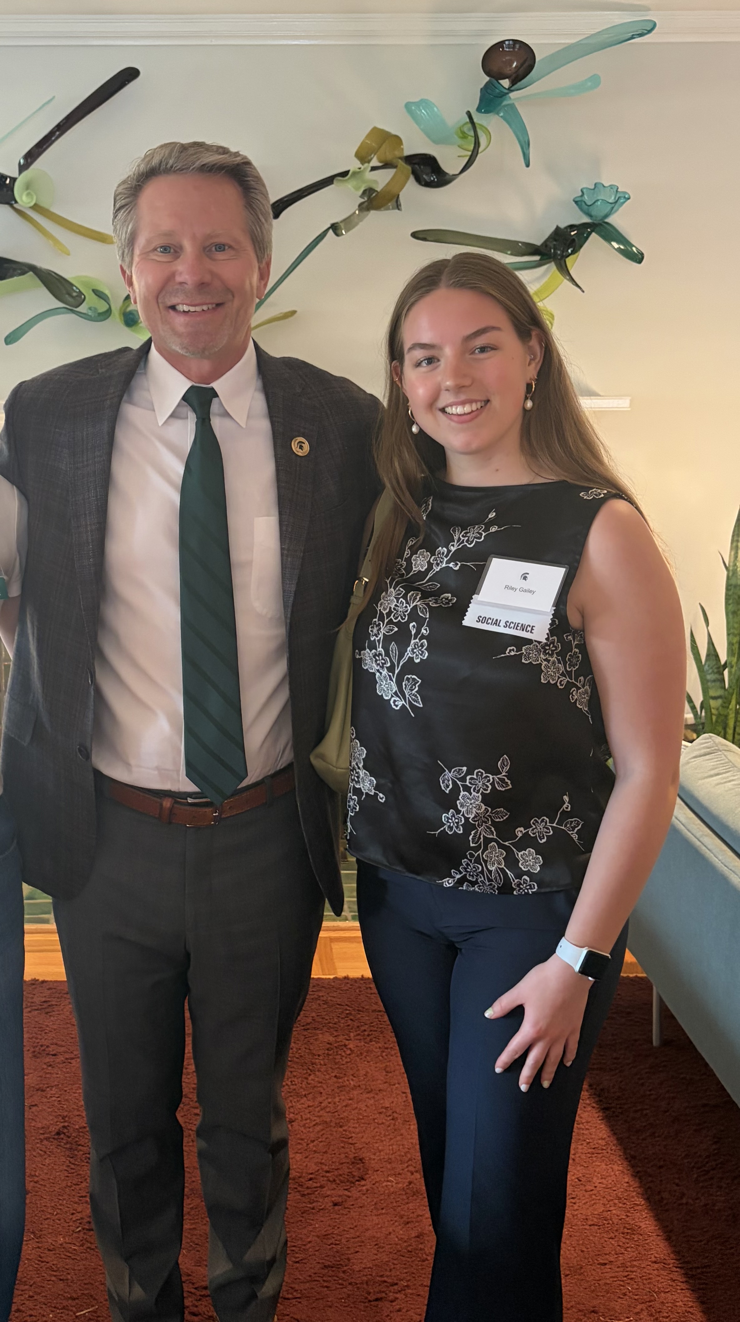 Riley Gailey standing next to MSU president Kevin Guskiewicz.