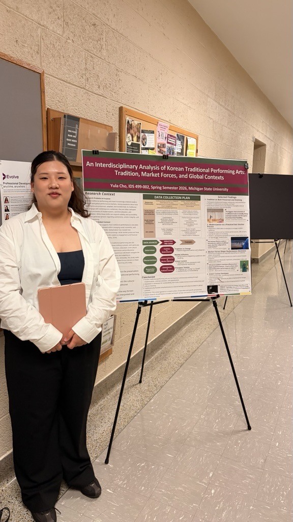 MSU student standing next to her poster display.